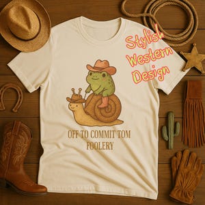 Rustic Cowboy Frog T-Shirt – “Off to Commit Tomfoolery” Funny Cottagecore Snail Rider Tee.