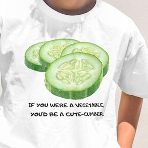 May include: White t-shirt with a graphic of cucumber slices and the text "If you were a vegetable, you'd be a cute-cumber."