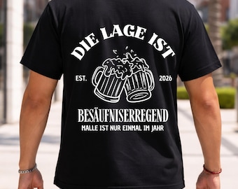 May include: Black t-shirt with white text and graphics. The design includes two beer mugs and the words "DIE LAGE IST BESÄUFNISERREGEND" and "MALLE IST NUR EINMAL IM JAHR". The shirt also has the year "2026".