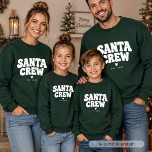May include: Matching dark green crewneck sweatshirts featuring the white text SANTA CREW in a bold, wavy font, with a small heart icon and the text EST. 2024 printed below. The sweatshirts have long sleeves and a classic fit, worn with blue jeans.