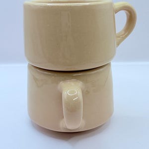 May include: A set of three ceramic mugs with a speckled, matte finish. The mugs are in shades of cream, light gray, and dark gray. Each mug has a simple, minimalist design, perfect for coffee or tea.