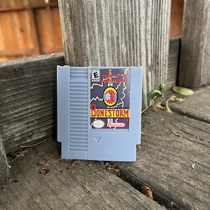 May include: A gray Nintendo Entertainment System (NES) game cartridge for the game 