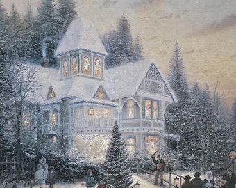 May include: A framed print depicting a snowy winter scene with a large house, a Christmas tree, and people gathered outside. The artwork features a white fence, a horse-drawn carriage, and a snowman. The color palette includes white, gray, and touches of warm light.