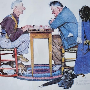 May include: Two men sit at a wooden table playing a board game. The table has a checkerboard pattern with red and black pieces. The men are wearing casual clothing and are focused on the game. A dog is lying on the floor beneath the table. The image is signed "Norman Rockwell".