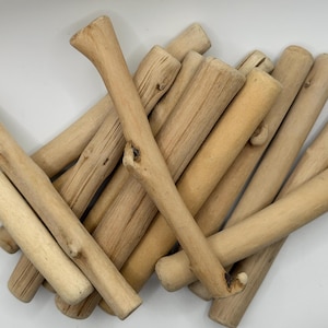 Könnte beinhalten: Eine Sammlung natürlicher Häkelnadeln aus Holz in verschiedenen hellbraunen Farbtönen. Die Häkelnadeln bestehen aus glattem, unbehandeltem Holz, mit einem gebogenen Haken an einem Ende und einem Griff am anderen. Die Haken sind in verschiedenen Größen und Formen.