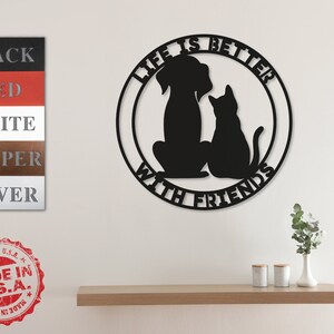 May include: Black metal wall decor with a dog and cat silhouette inside a circle. The text "Life is better with friends" is written around the circle.