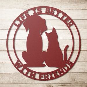 May include: A red metal sign with a dog and cat silhouette in the center. The sign reads "Life is better with friends".