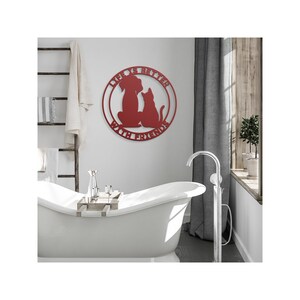 May include: Red metal wall art with a dog and cat silhouette inside a circle. The text reads "Life is better with friends".