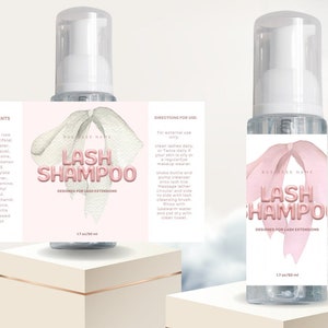 Pode incluir: Um modelo de etiqueta imprimível para garrafas de champô para pestanas. O rótulo apresenta um design rosa e branco com o texto "Lash Shampoo" e "Designed for Lash Extensions". O modelo é editável no Canva e permite personalizar a cor, a fonte, o texto, o logotipo, o tamanho e os ingredientes.