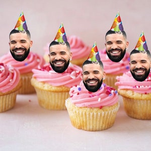 Könnte beinhalten: Sechs rosafarbene Cupcakes mit weißem Frosting und bunten Streuseln. Jeder Cupcake hat einen Geburtstagshut mit dem Gesicht eines Rappers.