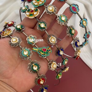 May include: Five silver headbands with colorful floral embellishments. Each headband features a different design with turquoise, red, green, and white stones. One headband has a small bird charm.