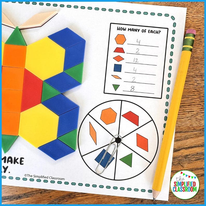 May include: An educational worksheet with geometric shapes and a pencil. The worksheet shows a butterfly made of shapes, a chart asking "How Many of Each?", and a shape spinner. A yellow pencil with a pink eraser rests on the page.
