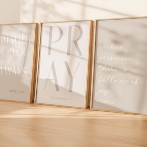 Może przedstawiać: Trzy oprawione wydruki z inspirującymi cytatami. Pierwszy wydruk głosi "I AM WITH YOU ALWAYS" z "Matthew 28:20" poniżej. Drugi wydruk mówi "PRAY" z "1 Tesaloniczan 5:17". Trzeci wydruk mówi "In his presence there is fullness of joy" z "Psalm 16:11".