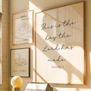 May include: Three framed art prints with inspirational quotes and line drawings. The largest print features the text "This is the day the Lord has made." The other prints include the phrases "in the morning when I rise" and "Jesus. Coffee."
