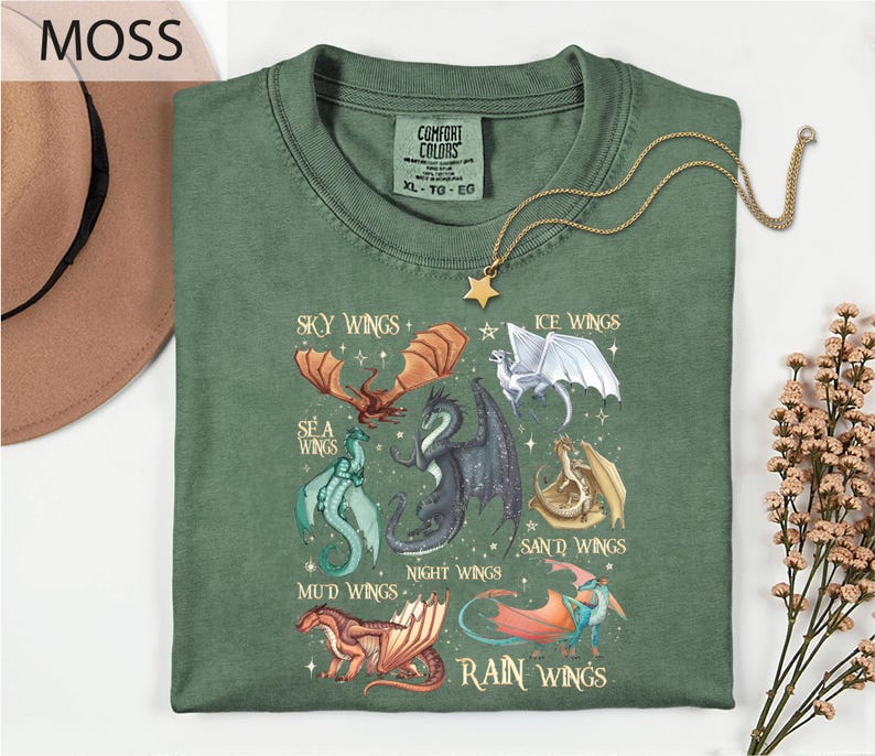 a green t-shirt with a graphic design of various dragon illustrations, including a red dragon, a blue dragon, and a white dragon, along with the text "MOSS" and "COMFORT COLLECTibles" printed on it.