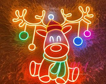 May include: A neon sign of a reindeer with a red hat and green scarf. The reindeer is holding a string of colorful ornaments. The sign is lit up in a warm orange glow.