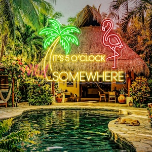 Könnte beinhalten: Eine tropische Szene mit einem Gebäude mit Strohdach und einem Neonschild mit der Aufschrift "IT'S 5 O'CLOCK SOMEWHERE". Das Schild zeigt eine grüne Neonpalme und einen rosa Neonflamingo. Ein Pool und tropische Pflanzen umgeben das Gebäude.
