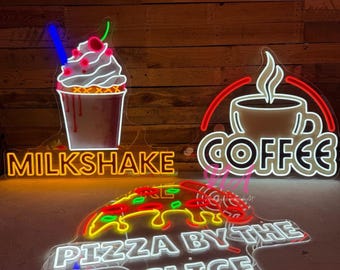 Puede incluir: Tres letreros de neón con un batido, café y pizza por porción. El letrero del batido es amarillo con la palabra "MILKSHAKE" en naranja. El letrero del café es rojo con la palabra "COFFEE" en blanco. El letrero de la pizza es blanco con las palabras "PIZZA BY THE SLICE" en blanco.