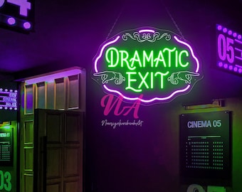 May include: A neon sign with the words "DRAMATIC EXIT" in green, outlined in pink, hangs in a dark room. The sign is above a door and next to a sign that says "CINEMA 05". The room is lit with purple and green lights.