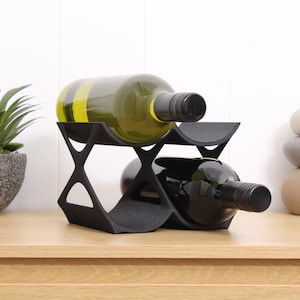 May include: Black metal wine rack with two bottles of wine, one white and one red.