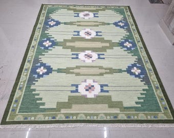 Alfombra color salvia, tejido plano de lana, borde geométrico, borde con flecos.