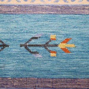 Blue and beige handwoven kilim rug with geometric tribal motifs; flatweave wool for boho living room decor.