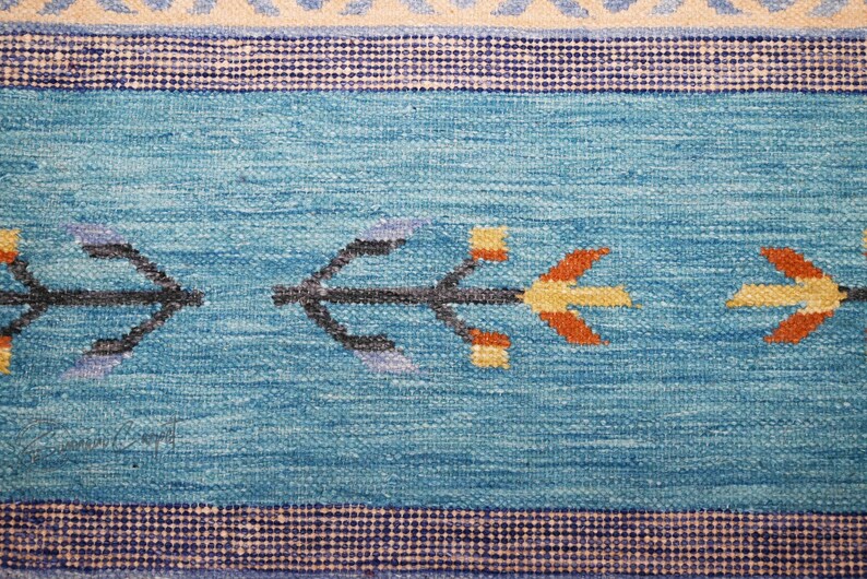 Blue and beige handwoven kilim rug with geometric tribal motifs; flatweave wool for boho living room decor.