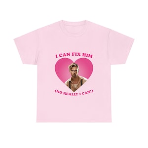 Puede incluir: Camiseta rosa claro con el texto "I CAN FIX HIM" en rosa sobre un corazón rosa. Dentro del corazón hay una foto de un hombre. Debajo del corazón está el texto "(NO REALLY I CAN!)" en rosa.