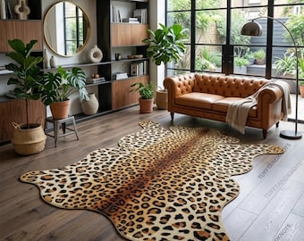 May include: A large, irregularly shaped area rug featuring a realistic leopard print pattern with black, brown, and tan spots. The rug is positioned on a dark wood floor in a room with a brown leather sofa, wooden shelving, and potted plants.