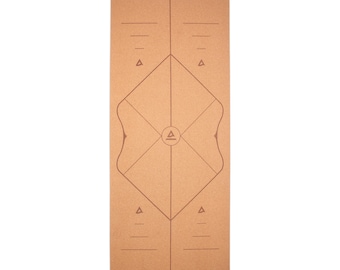 May include: A rectangular yoga mat in a natural cork color. The mat features a geometric design with lines, triangles, and a central emblem. The design is in a darker shade of brown. The mat is designed for yoga and fitness activities.