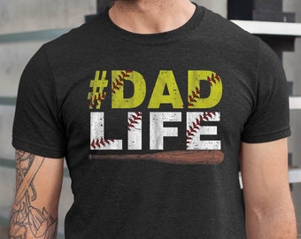 May include: A dark grey t-shirt with the text "#DADLIFE" in white with a yellow softball graphic and a baseball bat graphic.
