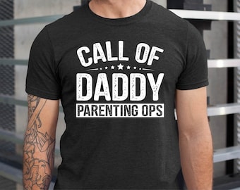 May include: A dark heather grey t-shirt with a white graphic that reads "Call of Daddy Parenting Ops".