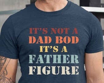 May include: A navy blue t-shirt with a vintage-style graphic that reads "It's not a dad bod, it's a father figure."