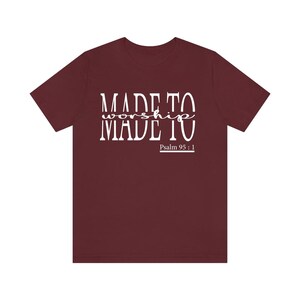 May include: Burgundy t-shirt with white text that reads "MADE TO worship MADE TO" and "Psalm 95:1".