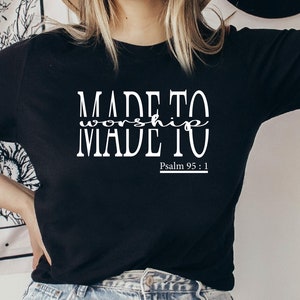 May include: Black t-shirt with white text that reads "MADE TO worship MADE TO" and "Psalm 95:1".