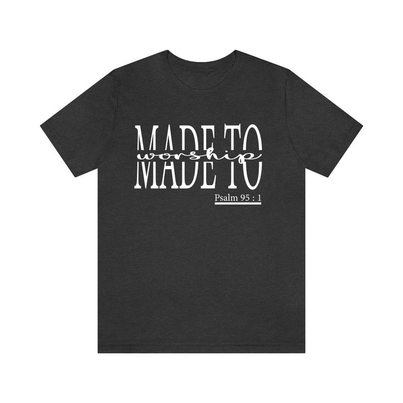 May include: A dark heather grey t-shirt with white text that reads "MADE TO worship MADE TO" and "Psalm 95:1"