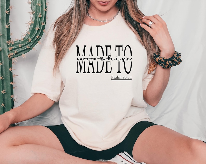 May include: A white t-shirt with black text that reads "MADE TO worship MADE TO" and "Psalm 95:1".