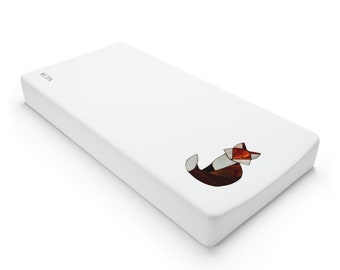 May include: White fitted cot sheet with a geometric fox design in shades of brown, orange, and red. The sheet has the word "ACPA" printed in black on the top left corner.
