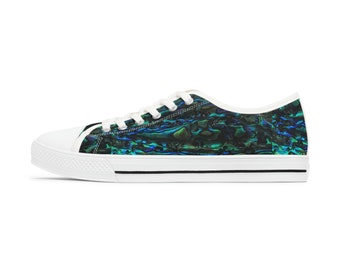 Può includere: Sneakers basse in tela bianca con un bordo nero attorno alla suola. Le scarpe presentano un motivo colorato iridescente che ricorda una conchiglia di abalone.