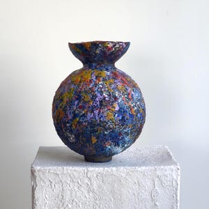 Abstract painted vessel with bold curvature and mineral blue ochre palette