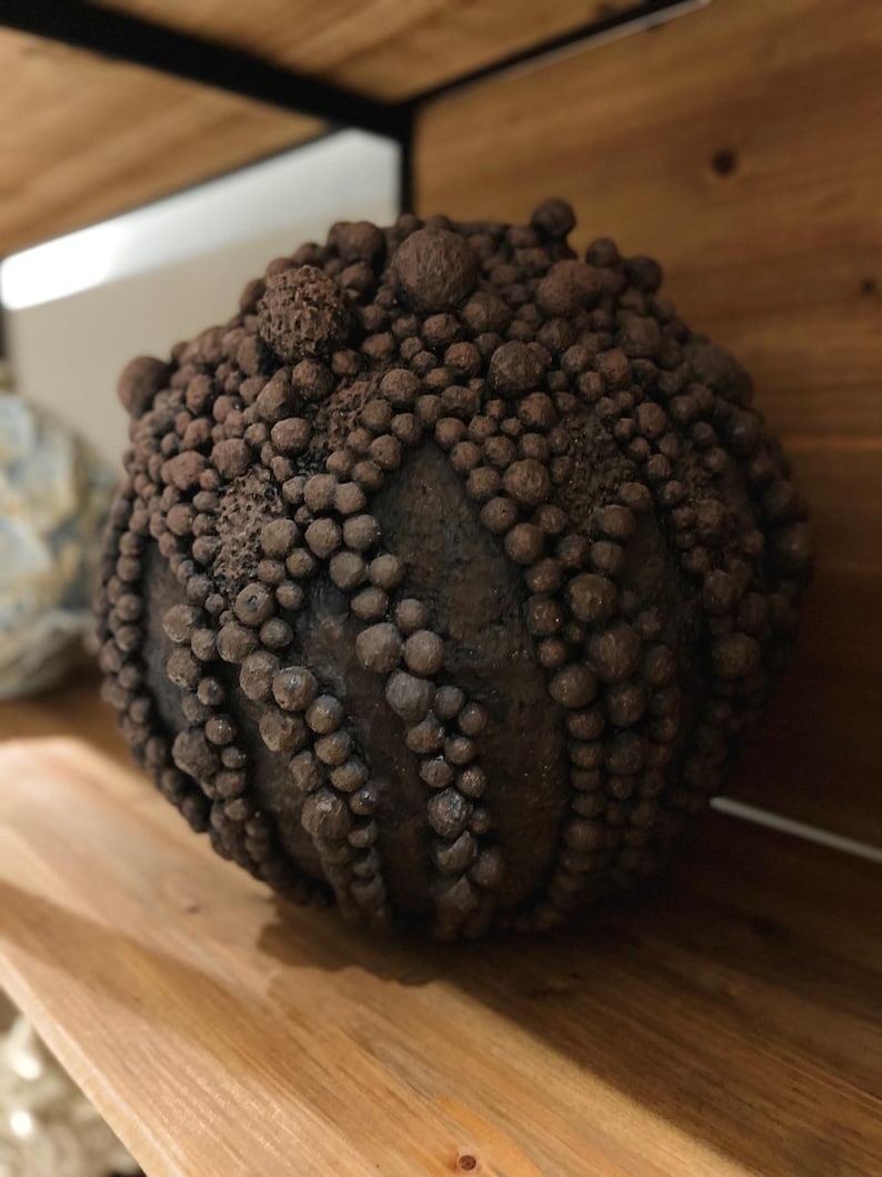 Handcrafted wabi-sabi vase with raw clustered texture and natural clay pigments.