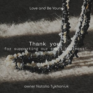 May include: Two strands of beaded necklaces made of black and white stones. The necklaces are on a light brown fuzzy surface. The text "Love and Be Young" is at the top of the image. The text "Thank you for supporting our small business!" is in the middle of the image. The text "owner Natalia Tykhoniuk" is at the bottom of the image.
