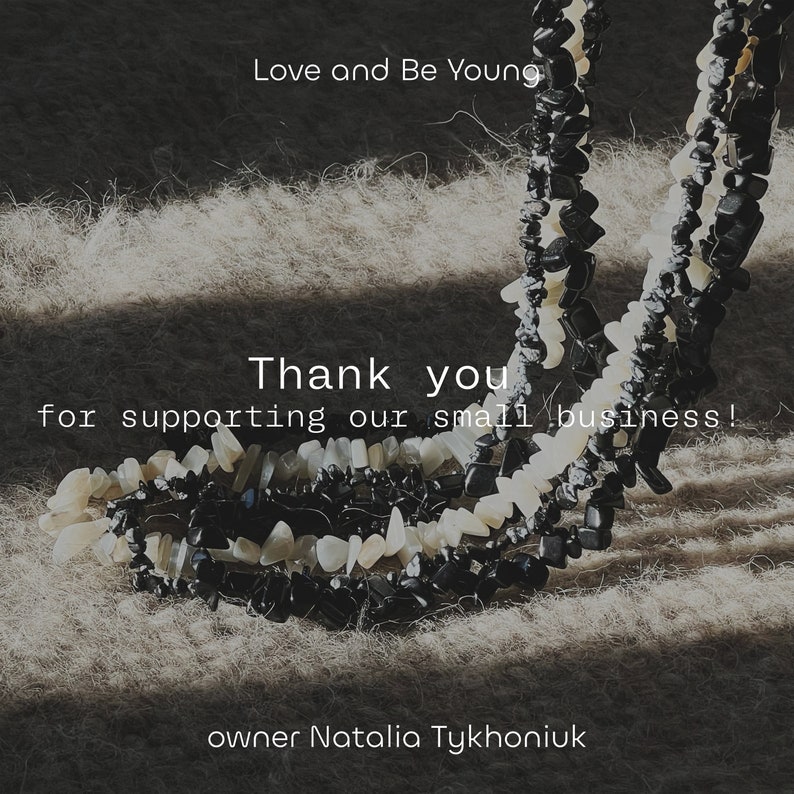 May include: Two strands of beaded necklaces made of black and white stones. The necklaces are on a light brown fuzzy surface. The text "Love and Be Young" is at the top of the image. The text "Thank you for supporting our small business!" is in the middle of the image. The text "owner Natalia Tykhoniuk" is at the bottom of the image.
