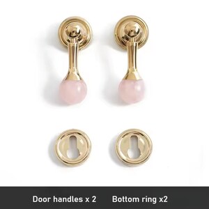 May include: Two gold door handles with pink crystal knobs and two matching gold bottom rings. Door handles x 2. Bottom ring x 2.