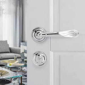 May include: A chrome door handle with a crystal-like lever and a matching round deadbolt.