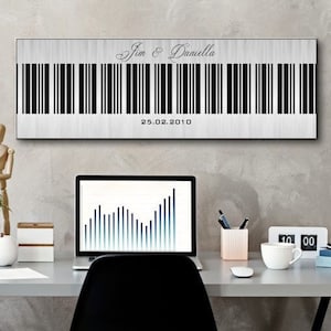 Può includere: Un'opera d'arte murale rettangolare con un design a codice a barre. L'opera presenta i nomi "Jim & Daniella" sopra il codice a barre e la data "25.02.2010" sotto. Lo sfondo è di colore argento chiaro e strutturato.