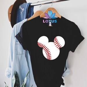 May include: Black t-shirt with a white baseball graphic in the shape of Mickey Mouse ears. The text "LOTUS DESIGN" is printed on the shirt.
