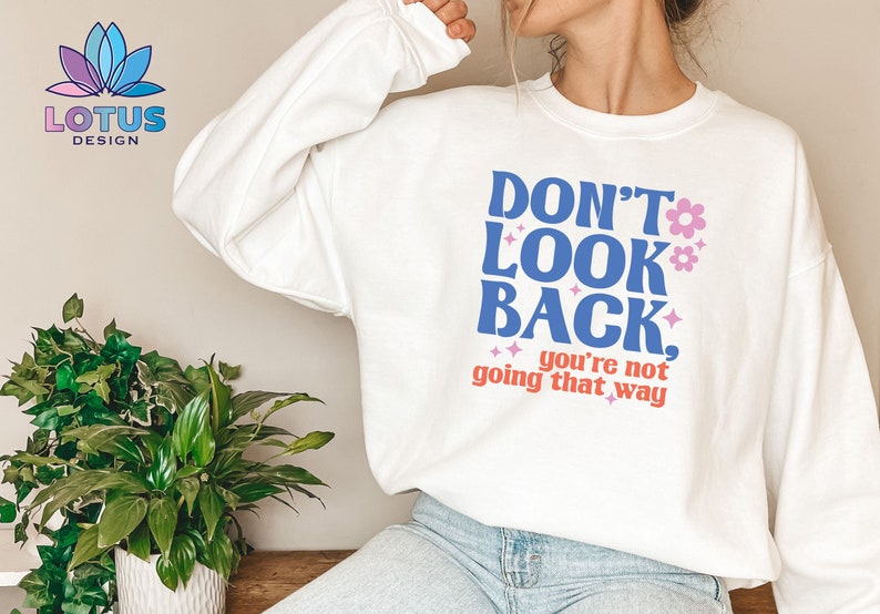 May include: White sweatshirt with a blue and pink graphic that says "Don't Look Back, you're not going that way".