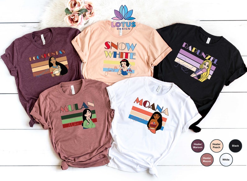 May include: Five different t-shirts featuring Disney princesses with retro-style graphics. The shirts are in various colours, including maroon, peach, white, and black. Each shirt features a different princess, including Pocahontas, Snow White, Rapunzel, Mulan, and Moana.