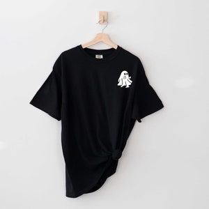 May include: Black t-shirt with a white ghost graphic on the front.